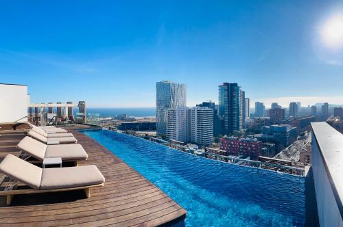 a swimming pool on top of a building with a city at Tembo Barcelona in Barcelona