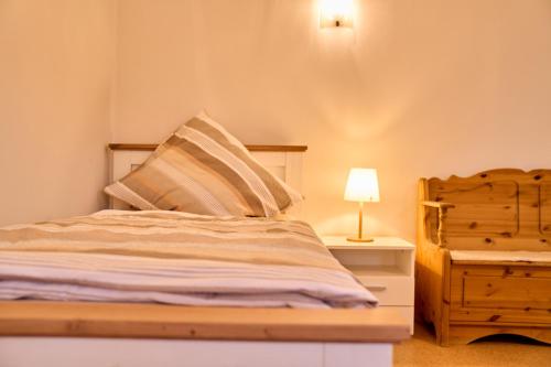 um quarto com uma cama e um candeeiro numa mesa de cabeceira em Ferienwohnung Brockenblick em Rennau