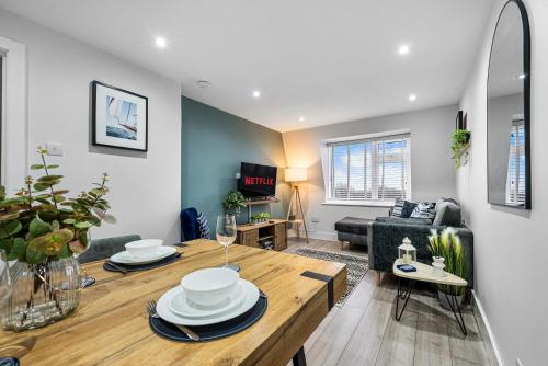 a living room with a table and a couch at Stunning, Spacious & Cosy 2-Bedroom Southsea Apartment, with Great Panoramic Views, Free Parking Permit, Sleeps 4 SPRING SPECIAL OFFER - by Blue Puffin Stays in Portsmouth