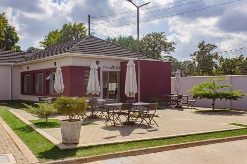a building with tables and umbrellas outside of it at Cherrywood Estate Limited in Blantyre