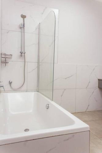 a white bathroom with a tub and a shower at Cherrywood Estate Limited in Blantyre