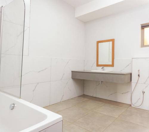 a white bathroom with a sink and a mirror at Cherrywood Estate Limited in Blantyre