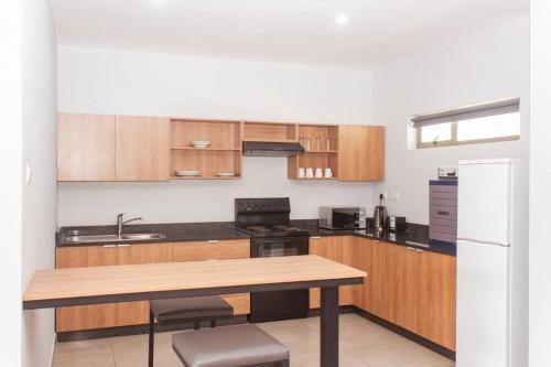 a kitchen with wooden cabinets and a wooden table at Cherrywood Estate Limited in Blantyre