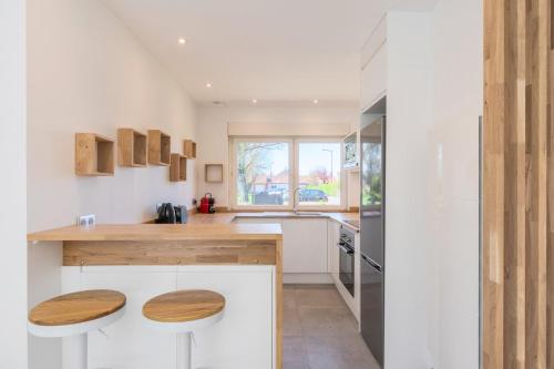 - une cuisine avec des murs blancs et des comptoirs en bois dans l'établissement Bright and renovated house for 8 people parking, à Marcq-en-Barœul