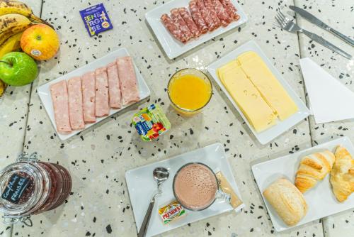 Una mesa cubierta con platos de desayuno y bebidas. en Montempô Appart'hôtel Paris Noisy Le Sec, en Noisy-le-Sec