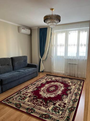 a living room with a blue couch and a rug at 2 комнатная квартира in Taldykolʼ