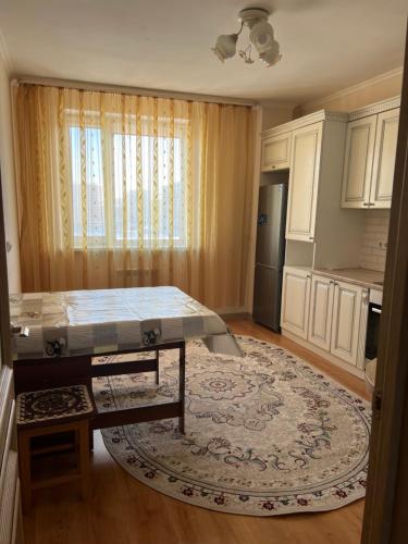 een keuken met een tafel in het midden van een kamer bij 2 комнатная квартира in Taldykolʼ