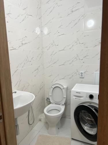 een witte badkamer met een toilet en een wastafel bij 2 комнатная квартира in Taldykolʼ