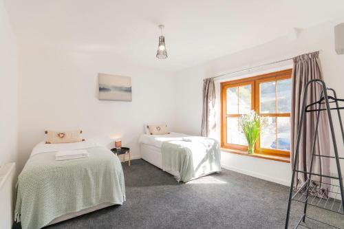 a white room with two beds and a window at The Space by Afan Valley Escapes in Port Talbot