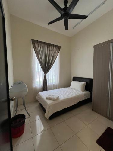 een slaapkamer met een bed en een raam bij D JANNAH HOMESTAY SERI ISKANDAR PERAK in Seri Iskandar