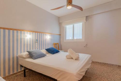 ein Schlafzimmer mit einem Bett mit zwei Kissen darauf in der Unterkunft Seaview Getaway: Beach Access, Pool & Tennis Court in Faro de Cullera