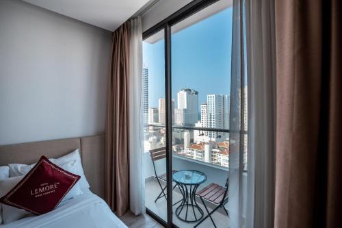 a hotel room with a bed and a balcony with a view at LeMore Hotel Nha Trang in Nha Trang