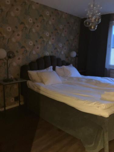 1 cama en un dormitorio con una pared floral en Riverside Apartments, en Ängelholm