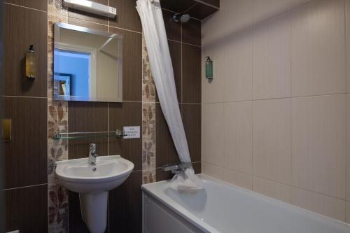 a bathroom with a sink and a toilet and a bath tub at The Romany Rye Wetherspoon in East Dereham