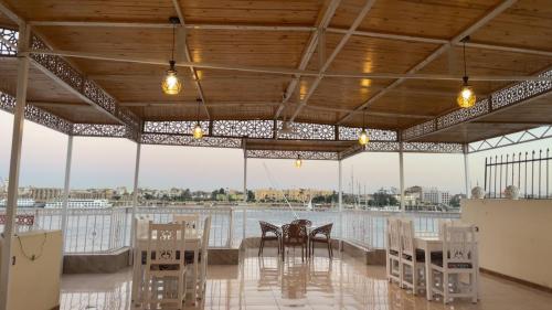 una zona de comedor con mesas y sillas en un pabellón en Full Moon House, en Luxor