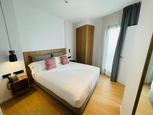 a bedroom with a large white bed with two pillows at Tembo Barcelona in Barcelona