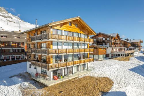 an apartment building in the snow on a mountain at Bella Vista in Fieschertal