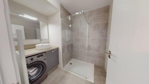 une salle de bain avec une machine à laver et un lavabo dans l'établissement Haut Saint Georges - Un emplacement exceptionnel au centre-ville et au calme à quelques pas du lac marin, à Soorts-Hossegor