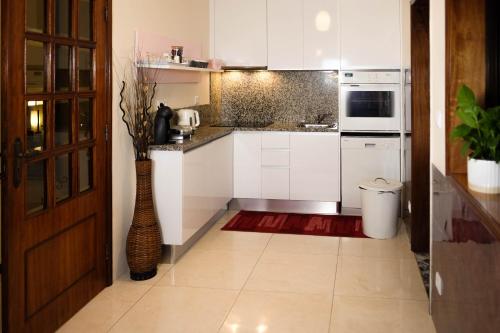 uma cozinha com armários brancos e um vaso em Eucalyptus Pink House em Covelo
