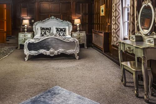 a bedroom with a bed and some tables and mirrors at The Pied Bull in Chester