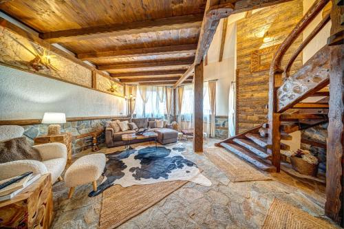 a living room with a spiral staircase in a house at Българче Хотел - Ресторант in Smolyan