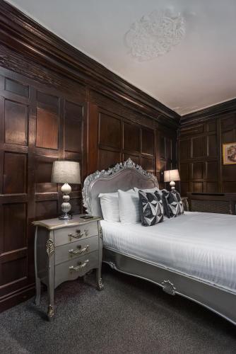 a bedroom with a bed and a table with a lamp at The Pied Bull in Chester