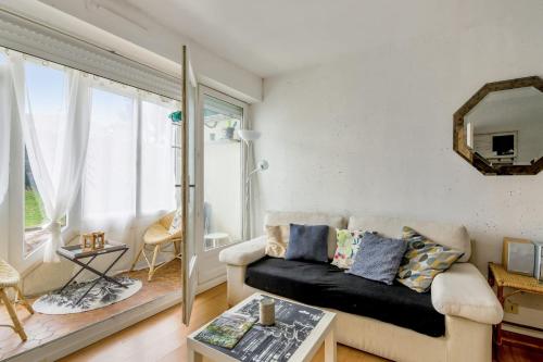 un salon avec un canapé et une grande fenêtre dans l'établissement Appartement Abbra - Welkeys, à Cabourg