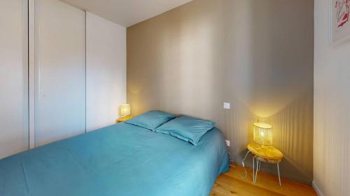 a bedroom with a blue bed and two lamps at TERRASSES SAINT GEORGES - Un emplacement exceptionnel au centre-ville et au calme à quelques pas du lac marin in Soorts-Hossegor