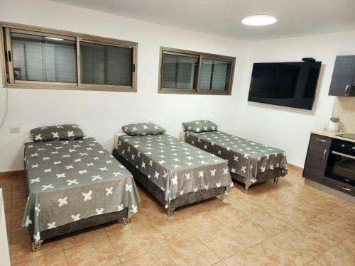 een kamer met 2 bedden en een flatscreen-tv bij Kati's Room in Eilat
