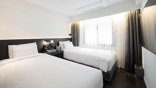 pokój hotelowy z 2 łóżkami i oknem w obiekcie Moyen Hotel w mieście Sokcho