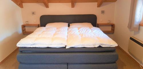 Bett mit zwei Kissen darüber in einem Zimmer in der Unterkunft Ferienhaus Pappenheimer in Regen