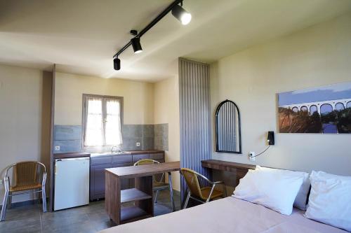 1 dormitorio con cama, mesa y cocina en Alekos Studios, en Diakofti