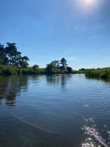 a river with a boat in the water at Przystań Stare Kotlice in Kotlice