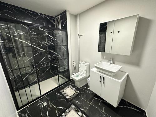 - une salle de bains en noir et blanc avec lavabo et toilettes dans l'établissement APARTİST 2, à Istanbul