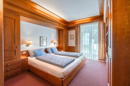 セルヴァ・ディ・ヴァル・ガルデーナにあるAppartamenti Sausalitoのベッドルーム1室(ベッド1台、大きな窓付)