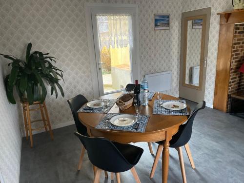 une table à manger avec des chaises, une table et une plante dans l'établissement chez mémère 3étoiles, à Saint-Blimont