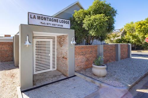 einen Eingang zu einem Haus mit einem Schild, das la mortgage lodge liest in der Unterkunft La Montagne Lodge in Riebeek-Kasteel