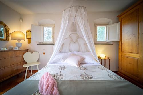 Una cama blanca con dosel en un dormitorio en Borgo Spedaletto 3 - Dolcevita Holiday, en Grassina