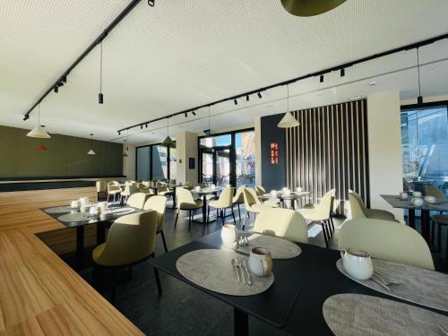 a dining room with tables and chairs and windows at Tembo Barcelona in Barcelona