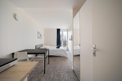 Cette chambre comprend une chambre, une table et un lit. dans l'établissement Le Mont neuf - Chambres avec cuisine au coeur de la nature type Appart'Hotel - sanitaires communs, à Perrigny