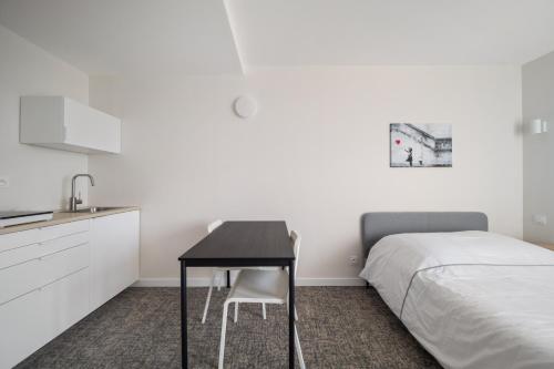 - une chambre avec un bureau à côté d'un lit et une cuisine dans l'établissement Le Mont neuf - Chambres avec cuisine au coeur de la nature type Appart'Hotel - sanitaires communs, à Perrigny