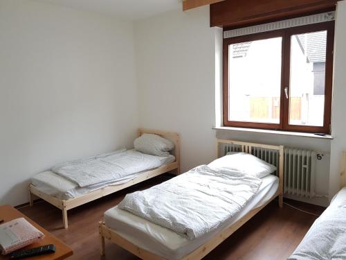 two beds in a room with a window at Monteurswohnungen Bruchsal Süd in Bruchsal