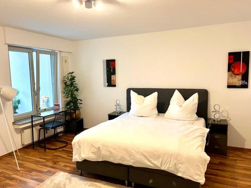a bedroom with a large bed with white sheets and pillows at Stylish, cosy flat close to Cologne City Center in Cologne