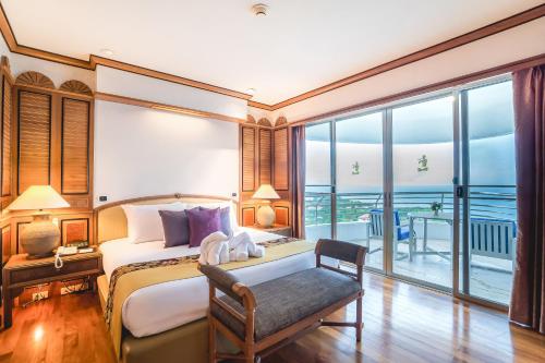 a bedroom with a bed and a desk and a window at Royal Cliff Grand Hotel Pattaya in Pattaya South