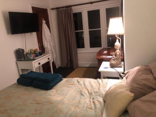 una camera con letto e scrivania con lampada di Lovely room in period townhouse a Winchester