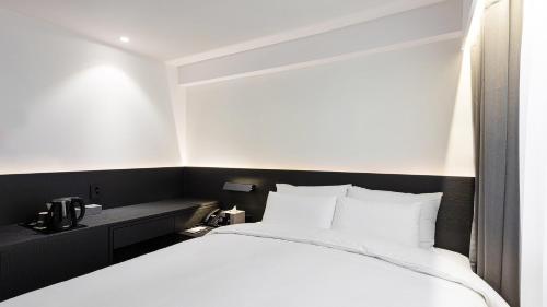 Ένα ή περισσότερα κρεβάτια σε δωμάτιο στο Moyen Hotel