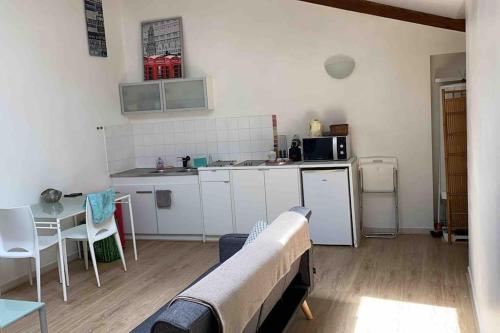 - une cuisine avec un canapé et une table dans une chambre dans l'établissement Le Saint-Lazare appartement au calme intra muros, à Avignon