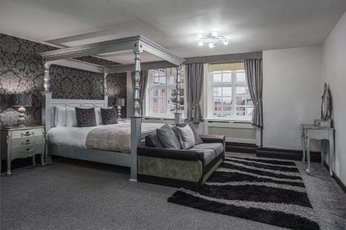 a bedroom with a canopy bed and a couch at The Pied Bull in Chester