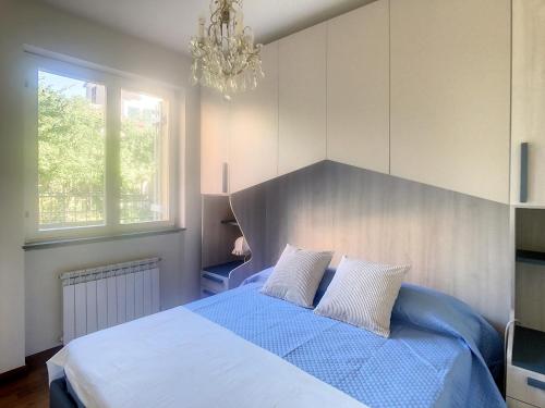 um quarto com uma grande cama azul e um lustre em Pertini House em Arenzano