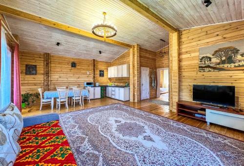 sala de estar amplia con TV y cocina en Домик в горах en Besqaynar
